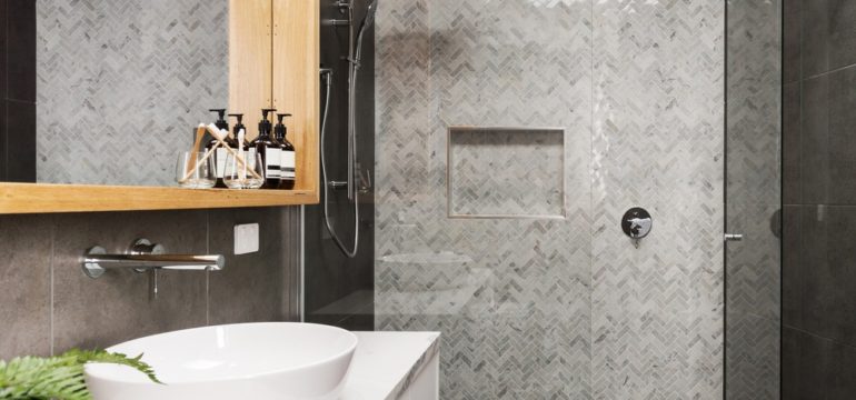 Bathroom renovation with grey herringbone tiles on the shower feature wall